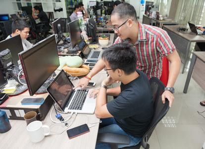 坐在办公桌前的亚洲同事软件开发团队照片